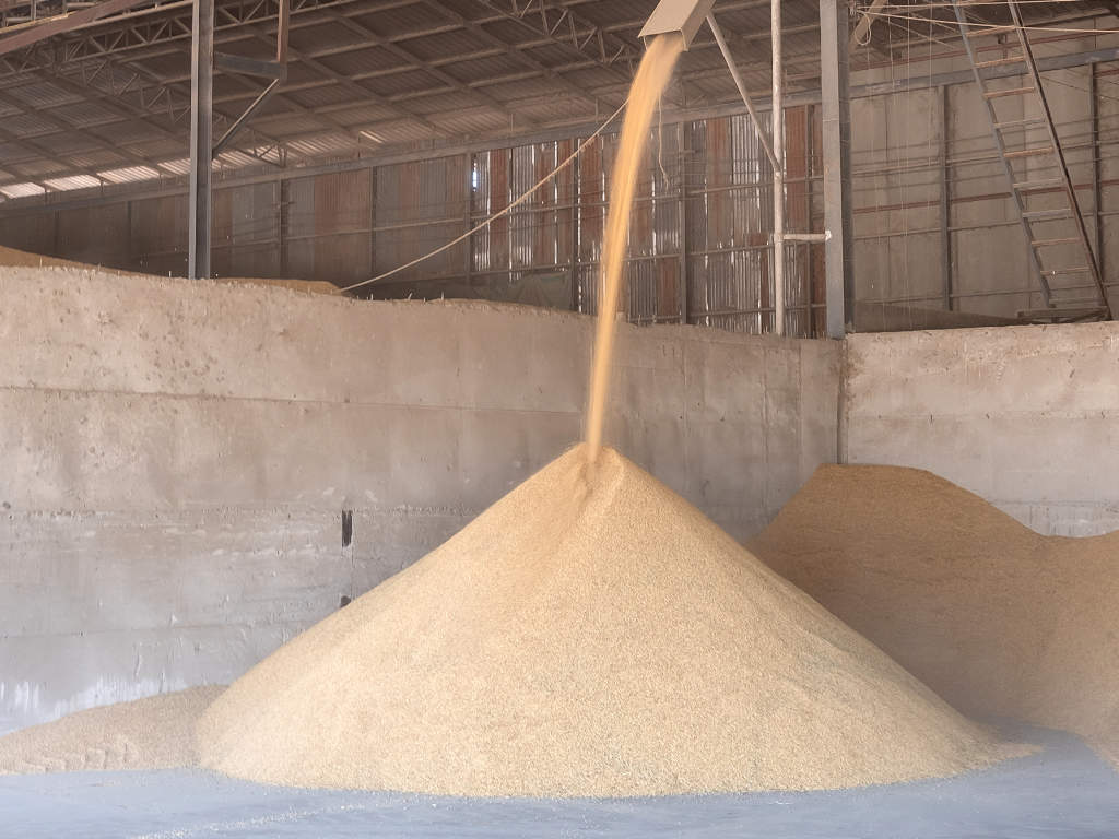 Bulk material pouring from chute into warehouse